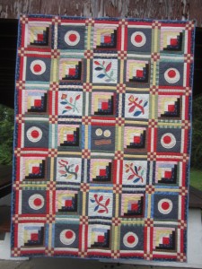 Round and assorted log cabin quilt by Jack Edson